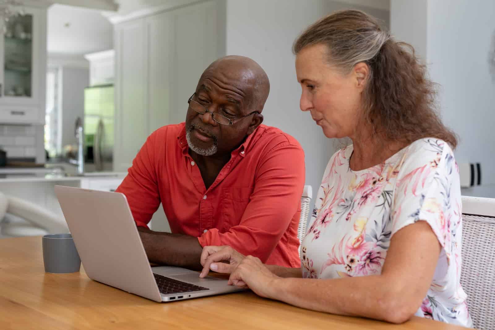 middle aged couple use their laptop to close their inactive accounts