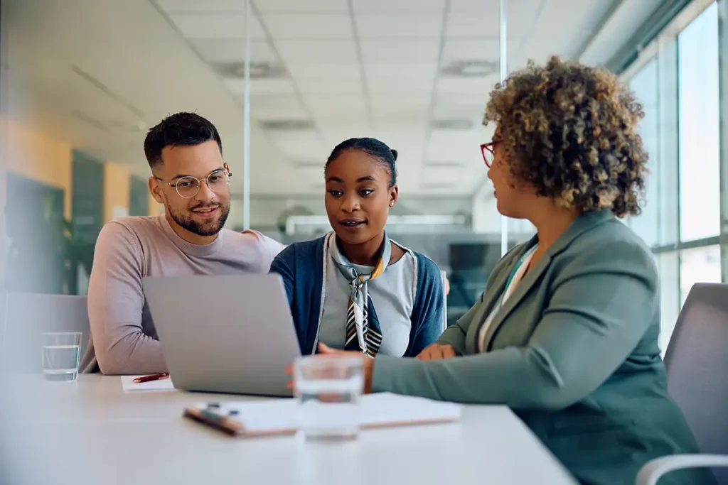 Young couple and their lawyer using computer while having a meeting in the office.